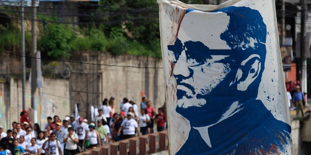 Pilgrims carry a portrait of Archbishop Oscar Romero in San Salvador, Saturday, May 23, 2015.