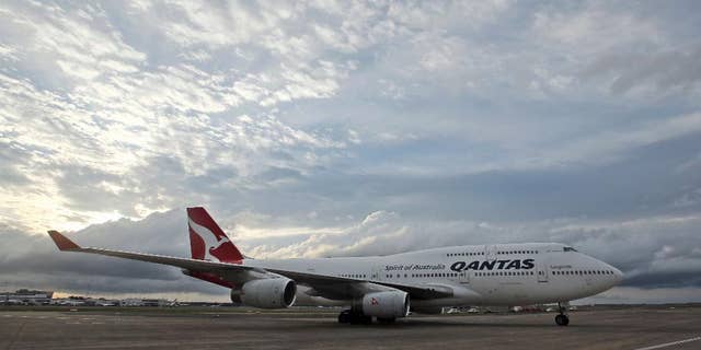FILE - In this Tuesday, Sept. 13, 2016 file photo, a Qantas jet taxis on the runway at Sydney Airport in Sydney, Australia. Around 100 passengers on board a Qantas regional jet in Australia were evacuated via the plane's emergency slides upon landing on Friday, Sept. 23 after the crew noticed fumes inside the cabin, officials said. (AP Photo/Rob Griffith, File)
