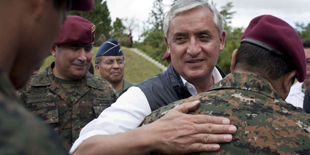 In this Dec. 5, 2011 file photo, Guatemala's President-elect Otto Perez Molina, center right, greets new members of Guatemala's Army elite special forces, "Kaibiles," at a graduation ceremony in Poptun, Guatemala.