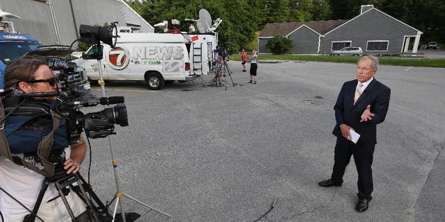 Television news crews gather Wednesday, June 10, 2015, near a business in Bolton, Mass., The business belonging to relatives of Keith Broomfield, an American fighting with Kurdish forces against the Islamic State group in Syria has been killed in battle, authorities said Wednesday, likely the first U.S. citizen to die fighting alongside them against the extremists. (AP Photo/Steven Senne)