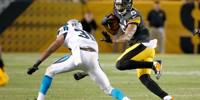 Pittsburgh Steelers wide receiver Justin Brown (15) tries to evade Carolina Panthers defensive back James Dockery (31) in the second quarter of a NFL preseason football game on Thursday, Aug. 28, 2014 in Pittsburgh. (AP Photo/Gene Puskar)