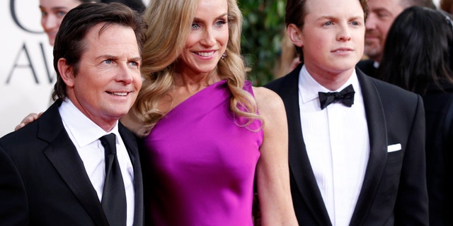 Actor Michael J. Fox, his wife Tracy Pollan and their son Sam Fox (R) arrive at the 70th annual Golden Globe Awards in Beverly Hills, California, January 13, 2013.