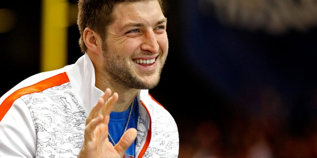 Former Florida Gators football star Tim Tebow waves to a crowd of fans.