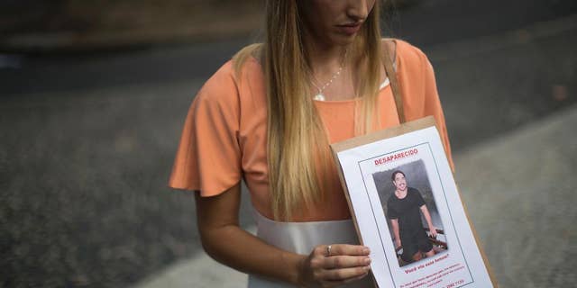 FILE - In this June 3, 2016 file photo, Bonnie Cuthbert, of Australia, shows a photo of her missing boyfriend Rye Hunt, 25, during a press conference in Rio de Janeiro, Brazil. Hunt, an electrician who worked at a mine in western Australian, was in Rio as part of a world trip with a friend where he was last seen on May 21. On Saturday, June 11, police confirmed that the body that washed up on a beach near Rio de Janeiro three days prior is Hunt, adding that investigators have not been able to establish the cause of death. (AP Photo/Felipe Dana, File)