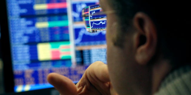 Graphs are reflected in the spectacles of a broker while working in a trading room of a Portuguese bank in Lisbon, Wednesday, Feb. 20, 2013. Portugal has raised euro 1.5 billion ($2 billion) in a debt sale, with the interest rate it is paying on a 12-month Treasury bill showing a significant drop as market confidence in the bailed-out country continues to improve. (AP Photo/Francisco Seco)