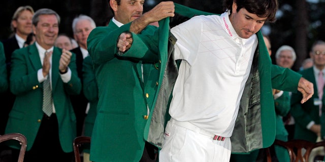 FILE- In this April 8, 2012, file photo, Charl Schwartzel, left, of South Africa, helps Bubba Watson put on the winner's green jacket after winning the Masters golf tournament on the 10th hole after a sudden death playoff in Augusta, Ga. Among the most pressing question for 2013: What will Watson serve for dinner at the Masters? (AP Photo/Darron Cummings, File)
