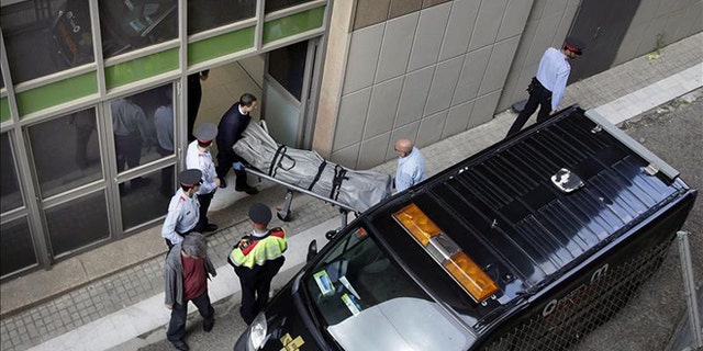 Coroner's office personnel remove the body of IES teacher Joan Fuster from the Barcelona school where a student opened fire on Monday, killing Fuster and injuring four others. (Photo: EFE)