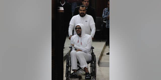 In this March 9, 2015 photo, Mohammed Soltan is pushed by his father Salah during a court appearance in Cairo, Egypt. Egyptian officials say authorities have freed Soltan, a dual U.S.-Egyptian citizen, Saturday May 30, 2015, Soltan had been sentenced to life in prison on charges of financing an anti-government sit-in and spreading "false news." (AP Photo/Heba Elkholy) ***EGYPT OUT***
