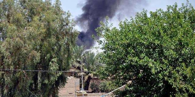 In this photo taken on Saturday, June 28, 2014, smoke rises during a military operation to regain control of Dallah Abbas north of Baqouba, the capital of Iraq's Diyala province, 35 miles (60 kilometers) northeast of Baghdad, Iraq. The Islamic State in Iraq and the Levant which already controls vast swaths in northern and eastern Syria amid the chaos of that nation's civil war, aims to erase the borders of the modern Middle East and impose its strict brand of Shariah law. (AP Photo)