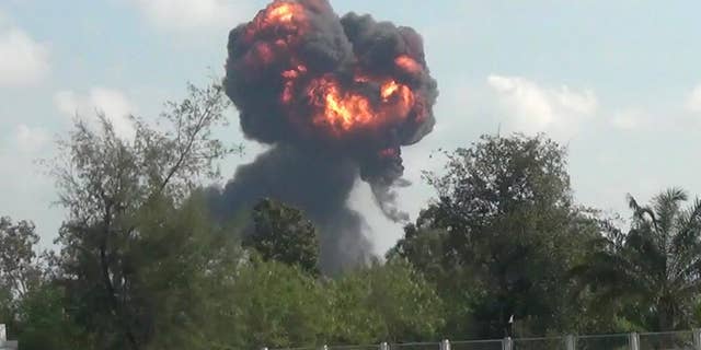 In this image made from video, a plume of smoke and fire rises from the site where a fighter jet crashed during and airshow, Saturday, Jan. 4, 2017, in Hat Yai, southern Thailand. A Thai air force pilot died when the JAS Gripen fighter jet crashed during an air show celebrating the country's Children's Day. (AP Photo)