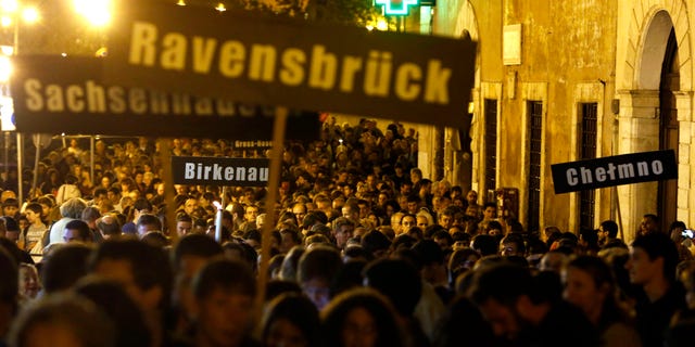 People hold up signs with names of Nazi concentration and death camps during a march marking the 70th anniversary of the roundup and deportation of Rome's Jews to concentration camps, in Rome's ghetto neighborhood, Wednesday, Oct. 16, 2013. Nazi forces rounded up more than 1,000 Jews from Rome's ghetto and nearby neighborhoods and sent them by train to Auschwitz. Only 16 survived. Rome's Jewish community, which gathered Wednesday amid deep anger over the late Nazi war criminal Erich Priebke and his Holocaust-denying final statement. Priebke died Friday in Rome, where he was serving a life term for his role in the 1944 massacre of 335 civilians at the Ardeatine Caves outside the capital. (AP Photo/Riccardo De Luca)