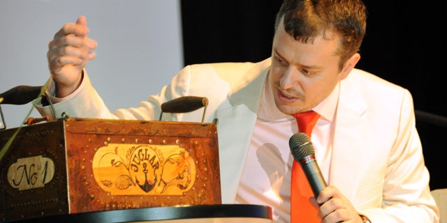 Auctioneer John Kapon from Acker Merrall & Condit stands next to a box containing a bottle of Juglar champagne. in Mariehamn, Finland, Friday June 3, 2011. Finnish officials say an Internet bidder has paid 54,000 euro ($78,235) for two bottles of 200-year-old champagne found in a shipwreck at the bottom of the Baltic Sea. Auctioneers in Mariehamn say that an anonymous buyer from Singapore paid a world-record price of 30,000 euro for a bottle of Veuve Clicquot and 24,000 euro for a bottle of Juglar. Both bottles are believed to be the oldest preserved examples of their respective brands. (AP Photo/Lehtikuva, Sari Gustafsson) FINLAND OUT NO SALES