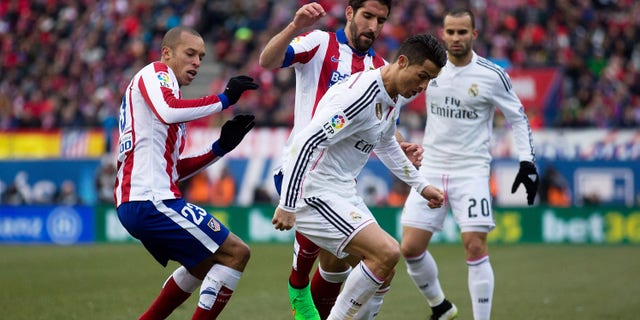 MADRID, SPAIN - FEBRUARY 07: Cristiano Ronaldo (R) of Real Madrid CF competes for the ball with Raul Garcia (2ndL) of Atletico de Madrid and his teammate Joao Miranda (L) during the La Liga match between Club Atletico de Madrid and Real Madrid CF at Vicente Calderon Stadium on February 7, 2015 in Madrid, Spain. (Photo by Gonzalo Arroyo Moreno/Getty Images)