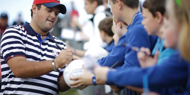 Patrick Reed of the US signs autographs for fans on his way to the 9th tee box during a practice round ahead of the Ryder Cup golf tournament, at Gleneagles, Scotland, Wednesday, Sept. 24, 2014. (AP Photo/Matt Dunham)