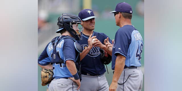 Tampa Bay Rays starting pitcher Matt Moore, center, talks with pitching coach Jim Hickey (48) and catcher Ryan Hanigan (24) in the third inning of an exhibition baseball game against the Boston Red Sox in Fort Myers, Fla., Sunday, March 23, 2014. THe Rays won 9-2. (AP Photo/Gerald Herbert)