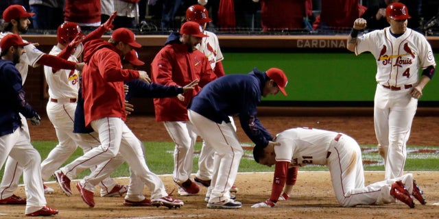 Teammates mob St. Louis Cardinals' Allen Craig at home after Craig scored the game-winning run on an obstruction call during the ninth inning of Game 3 of baseball's World Series against the Boston Red Sox Saturday, Oct. 26, 2013, in St. Louis. (AP Photo/Charlie Riedel)