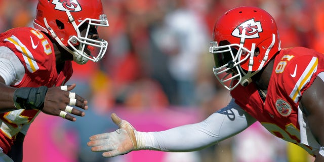 ADVANCE FOR WEEKEND EDITIONS, OCT. 26-27 - FILE - In this Oct. 13, 2013, file photo, Kansas City Chiefs outside linebackers Justin Houston (50) and Tamba Hali (91) celebrate a sack of Oakland Raiders quarterback Terrelle Pryor during an NFL football game in Kansas City, Mo. Both of them get to the quarterback with such frequency that opposing coaches have to pick their poison. They're the two biggest playmakers on the Chiefs' defense. In some ways, you could call them the H-factor. (AP Photo/Reed Hoffmann, File)