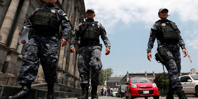 FILE: Police officers walk on the main square a day after local election in Toluca, Mexico.