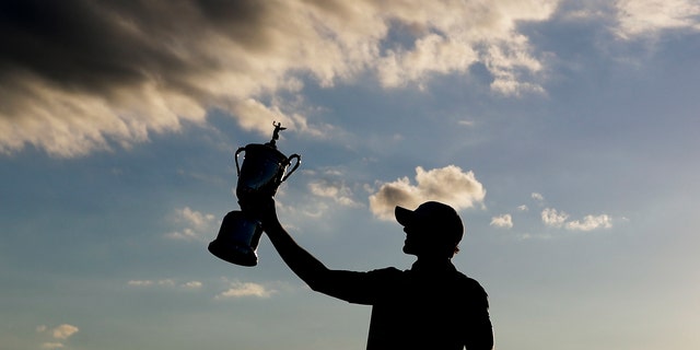 Brooks Koepka poses with the winning trophy after the U.S. Open golf tournament, June 18, 2017, at Erin Hills in Erin, Wis. (Associated Press)