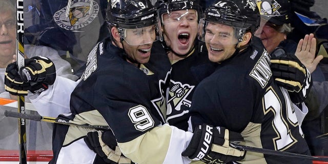 Pittsburgh Penguins' Olli Maatta, center, celebrates his first NHL career goal with teammates Pascal Dupuis (9) and Chris Kunitz (14) in the third period of a NHL hockey game against the Vancouver Canucks in Pittsburgh Saturday, Oct. 19, 2013. The Penguins won in an overtime shootout, 4-3. (AP Photo/Gene J. Puskar)