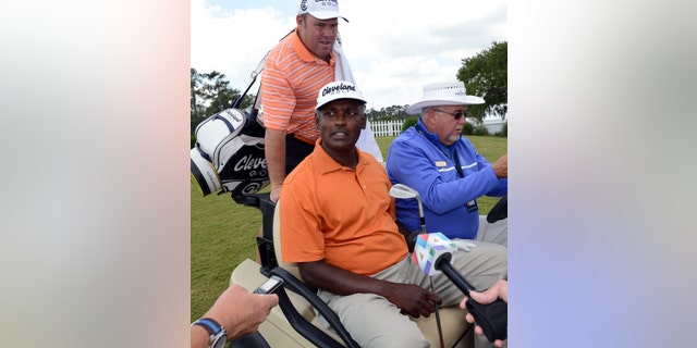 Vijay Singh sits in a cart driven by Doug Kidd, of TPC Sawgass Golf Operations after his practice round at The Players Championship golf tournament Wednesday, May 8, 2013, in Ponte Vedra Beach, Fla. Singh sued the PGA Tour on Wednesday for exposing him to "public humiliation and ridicule" during a 12-week investigation into his use of deer antler spray that ended last week when the tour dropped its case against him. (AP Photo/The Florida Times-Union, Bob Mack)