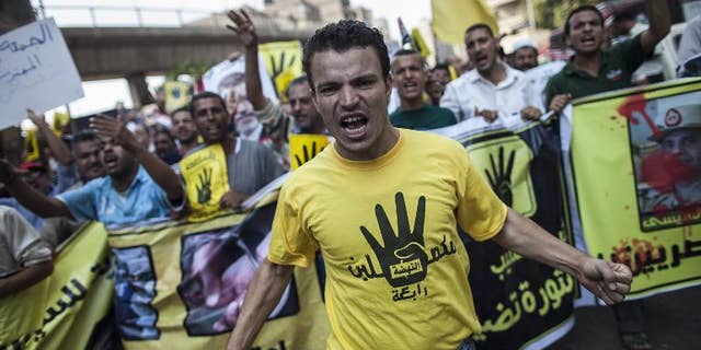 Members of the Muslim Brotherhood and supporters of ousted President Mohamed Morsi march through Cairo on September 6, 2013, wearing the hand logo recently adopted by the group