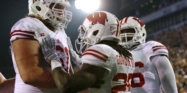 Wisconsin running back Melvin Gordon, center, celebrates with teammates after scoring on a 23-yard touchdown run in the second half of an NCAA college football game against Iowa, Saturday, Nov. 22, 2014, in Iowa City, Iowa. Wisconsin won 26-24. (AP Photo/Charlie Neibergall)