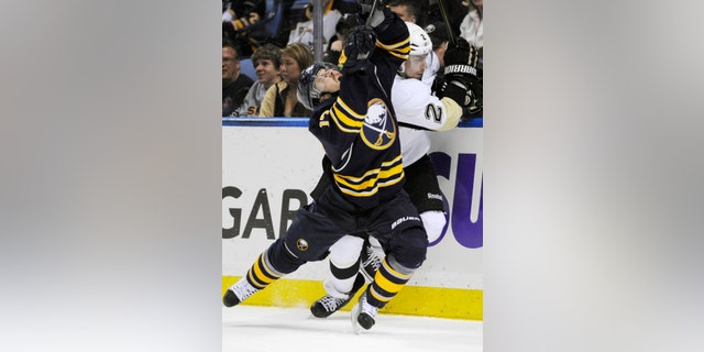 Buffalo Sabres' Linus Omark (17), of Sweden, grimaces after a check on Pittsburgh Penguins' Matt Niskanen (2) during the first period of an NHL hockey game in Buffalo, N.Y., Wednesday, Feb. 5, 2014. Pittsburg won 5-1. (AP Photo/Gary Wiepert)