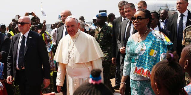 FILE- In this Sunday Nov. 29, 2015 file photo, Pope Francis arrives in Bangui, Central African Republic, on the third leg of his trip to Africa. Heavy gunfire, a grenade and threats of violence in Central African Republic on Sunday Dec.13, 2015,  prevented some residents from participating in a constitutional referendum aimed at moving the country out of a transition and toward stability. The vote on a new constitution adopted by the transitional government comes nearly two weeks after a visit by Pope Francis, who called for peace and Muslim-Christian reconciliation. (AP Photo/Jerome Delay, File)