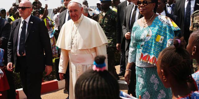 FILE- In this Sunday Nov. 29, 2015 file photo, Pope Francis arrives in Bangui, Central African Republic, on the third leg of his trip to Africa. Heavy gunfire, a grenade and threats of violence in Central African Republic on Sunday Dec.13, 2015, prevented some residents from participating in a constitutional referendum aimed at moving the country out of a transition and toward stability. The vote on a new constitution adopted by the transitional government comes nearly two weeks after a visit by Pope Francis, who called for peace and Muslim-Christian reconciliation. (AP Photo/Jerome Delay, File)