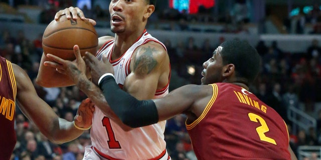 Chicago Bulls point guard Derrick Rose (1) drives past Cleveland Cavaliers point guard Kyrie Irving (2) during the second half of an NBA basketball game Monday, Nov. 11, 2013, in Chicago. The Bulls won 96-81. (AP Photo/Charles Rex Arbogast)
