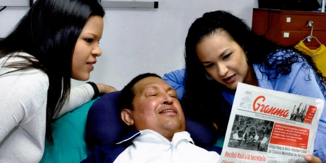 In this photo released Friday, Feb. 15, 2013 by Miraflores Presidential Press Office, Venezuela's President Hugo Chavez, center, poses for a photo with his daughters, Maria Gabriela, left, and Rosa Virginia as he holds a copy of Cuba's state newspaper at an unknown location in Havana, Cuba, Thursday, Feb. 14, 2013. Chavez remains in Havana undergoing unspecified treatments following his fourth cancer-related operation on Dec. 11. He has hasn't been seen or spoken publicly in more than two months. (AP Photo/Miraflores Presidential Press Office)
