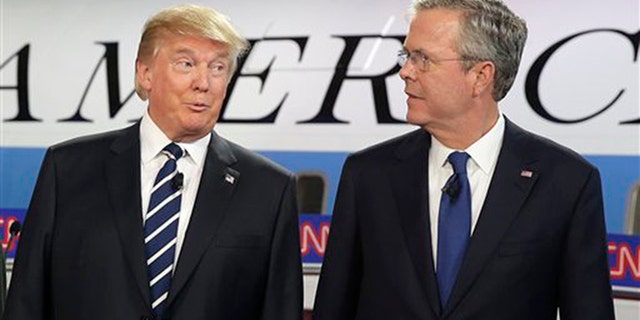 Republican presidential candidates Donald Trump and Jeb Bush talk together before the start of the debate at the Ronald Reagan Presidential Library.