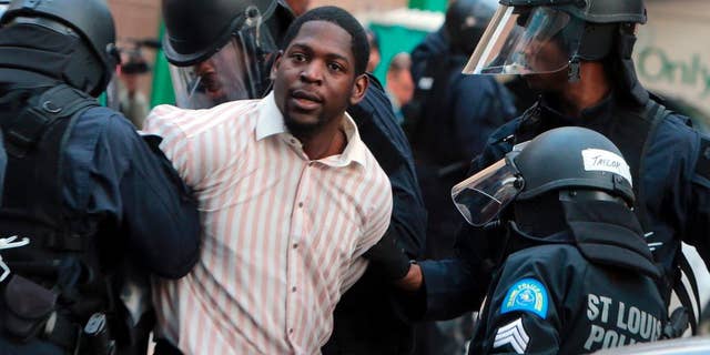 Police arrest protester Derrick Robinson, Sunday, Nov. 30, 2014, in St. Louis.