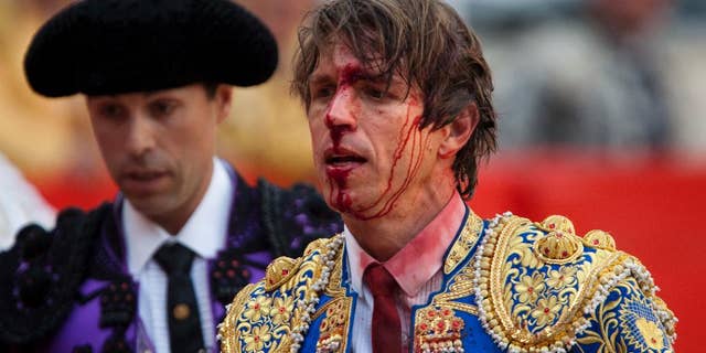FILE - In this April 25, 2010 file photo, bullfighter Manuel Diaz "El Cordobes", right, reacts after being gored by a bull during a bullfight at the Monumental Bullring in Barcelona, Spain. The southern Cordoba city court has held a hearing into a decades-old paternity dispute over whether two of Spain's most well-known bullfighters and who share the same showname, 'El Cordobes', are really father and son. The court began studying the claim Thursday April 28, 2016 by Manuel Diaz, 47 that he is the son of retired bullfighting legend Manuel Benitez, 79, something the elder torero has never recognized. (AP Photo/Emilio Morenatti, File)