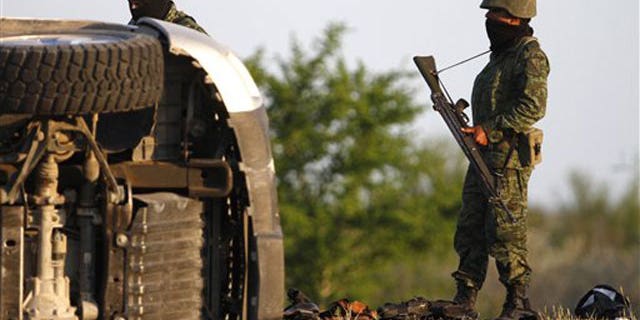 March 30: Soldiers stand by an overturned vehicle after a shootout on the outskirts of Monterrey, Mexico.