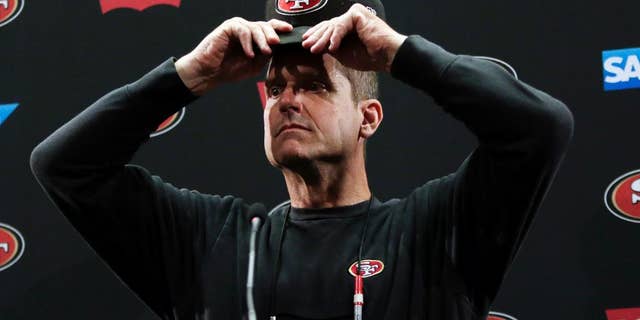 San Francisco 49ers head coach Jim Harbaugh adjust his cap as he answers questions from the media during an NFL football training camp on Thursday, July 24, 2014, in Santa Clara, Calif. (AP Photo)