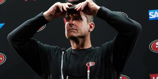San Francisco 49ers head coach Jim Harbaugh adjust his cap as he answers questions from the media during an NFL football training camp on Thursday, July 24, 2014, in Santa Clara, Calif. (AP Photo)