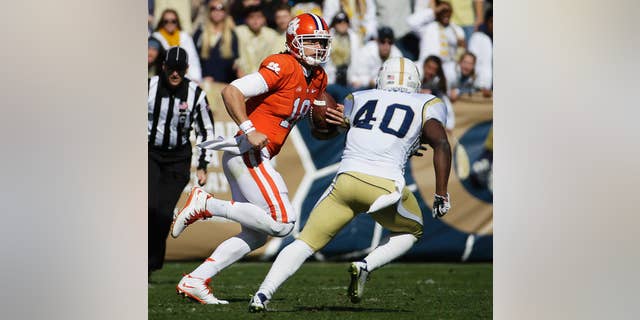 Clemson quarterback Cole Stoudt, left, is chased while running the ball by Georgia Tech's Paul Davis in the second quarter of an NCAA college football game, Saturday, Nov. 15, 2014, in Atlanta. Georgia Tech won 28-6. (AP Photo/David Goldman)