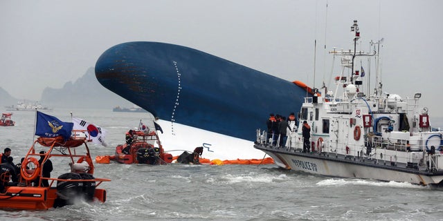 South Korean Coast Guard officers try to rescue missing passengers from a sunken ferry in the water off the southern coast near Jindo, south of Seoul, South Korea, Thursday, April 17, 2014.  Fears rose Thursday for the fate of more than 280 passengers still missing more than 24 hours after their ferry flipped onto its side and filled with water off the southern coast of South Korea. (AP Photo/Yonhap) KOREA OUT