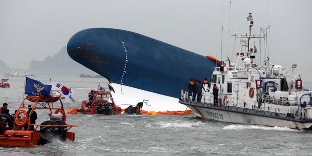 South Korean Coast Guard officers try to rescue missing passengers from a sunken ferry in the water off the southern coast near Jindo, south of Seoul, South Korea, Thursday, April 17, 2014. Fears rose Thursday for the fate of more than 280 passengers still missing more than 24 hours after their ferry flipped onto its side and filled with water off the southern coast of South Korea. (AP Photo/Yonhap) KOREA OUT