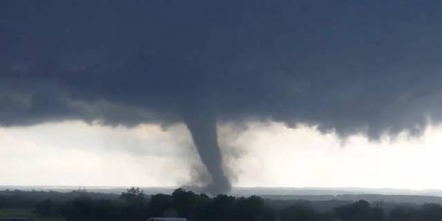 This image made from a video taken through a car window shows a tornado near Wynnewood, Okla., Monday, May 9, 2016. A broad tornado capable of leaving "catastrophic" damage in its wake churned across the Oklahoma landscape Monday, prompting forecasters to declare a tornado emergency for two communities directly in its path. (Hayden Mahan via AP) MANDATORY CREDIT