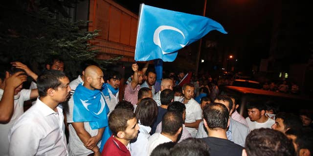 Uighurs living in Turkey and Turkish supporters, some carrying flags of East Turkestan, the term separatist Uighurs and Turks use to refer to the Uighurs homeland in China's Xinjiang region, gather outside the Thai consulate in Istanbul, early Thursday, July 9, 2015. A group of protesters stormed the consulate overnight, smashing windows and breaking into the offices (AP Photo)