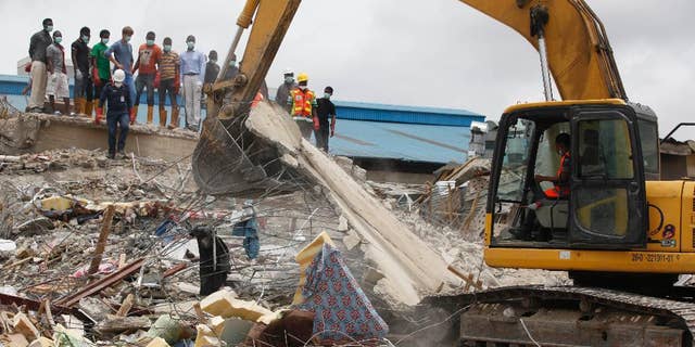 FILE - In this Wednesday, Sept. 17, 2014 file photo, rescue workers search for survivors in the rubble of a collapsed building belonging to the Synagogue Church of All Nations in Lagos, Nigeria. The Synagogue Church of All Nations of televangelist T. B. Joshua on Thursday, July 9, 2015 rejected a coroner’s report recommending prosecution of the Nigerian church and two structural engineers in the collapse of a church building that killed 116 people, most of them visitors from South Africa. (AP Photo/Sunday Alamba, File)