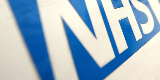 FILE In this Dec. 12, 2010 file photo of the NHS Logo. The British Red Cross says overcrowding in hospital emergency rooms has become a "humanitarian crisis." The charity says it has dispatched volunteers to help patients go home and free up hospital beds. It claims cuts to social-care funding by the Conservative government mean some patients can't be discharged because there is no support available, putting pressure on hospitals. Government supporters say the Red Cross is exaggerating the scale of the problem. (Dominic Lipinski/PA via AP, File)