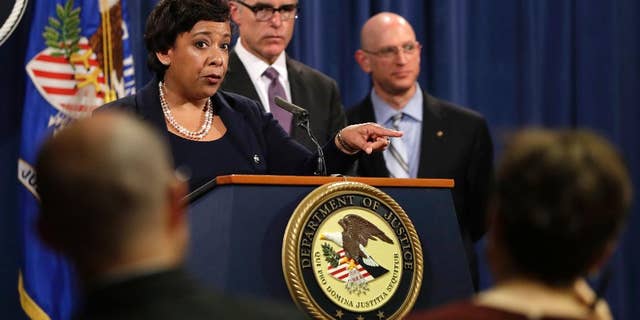 Attorney General Loretta Lynch, left, next to FBI Deputy Director Andrew McCabe and IRS Criminal Division Chief Richard Weber, speaks at a news conference, Wednesday, July 20, 2016, at the Justice Department in Washington, announcing that the U.S. government is seeking the forfeiture of more than $1 billion in assets that federal officials say were misappropriated from a Malaysian sovereign wealth fund. (AP Photo/Jacquelyn Martin)
