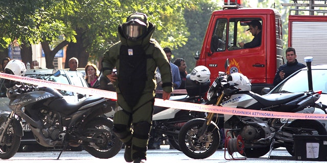 Nov. 1: A police officer prepares for a controlled explosion of a suspect package in Athens, Greece.