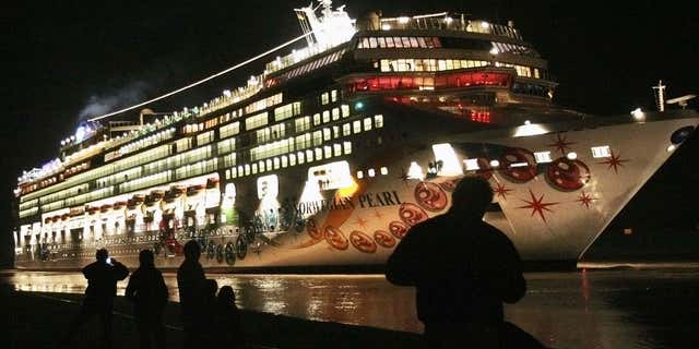 Nov. 7, 2006: People stand on a dyke watching the newly built cruise ship 'Norwegian Pearl' on its passage from the Meyer shipyard in Papenburg to the North Sea.