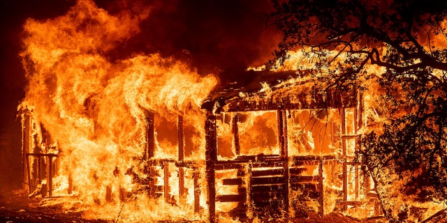 A structure burns as the Carr Fire races along Highway 299 near Redding, Calif., on Thursday, July 26, 2018.