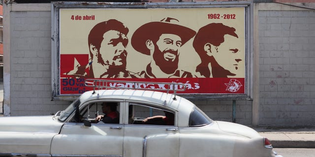 HAVANA, CUBA - MARCH 26: A billboard celebrating some of Cuba's revolutionary heroes (L-R) Che Guevara, Camilo Cienfuegos and Julio Mella , hangs on a wall on the day that Pope Benedict XVI is scheduled to arrive in Cuba on March 26, 2012 in Havana, Cuba. Pope Benedict, who will be arriving from Mexico, will conduct a mass in the city of Santiago de Cuba first followed by a mass in Havana before leaving on the March 28.Tensions are high in Cuba between some dissidents and the government as activists hope the international exposure of the Papal visit will result in renewed attention to their struggle (Photo by Joe Raedle/Getty Images)